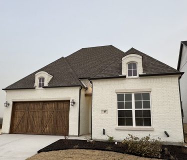 A beautifully painted modern home exterior in Fort Worth, featuring pristine white brick siding, elegant windows, and a well-maintained driveway.