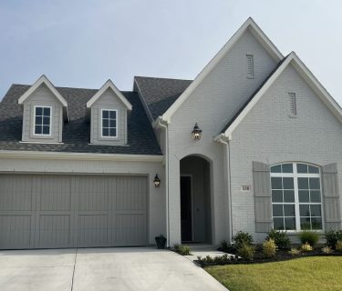 Elegant light gray single-story house with a double garage and manicured lawn in Fort Worth.